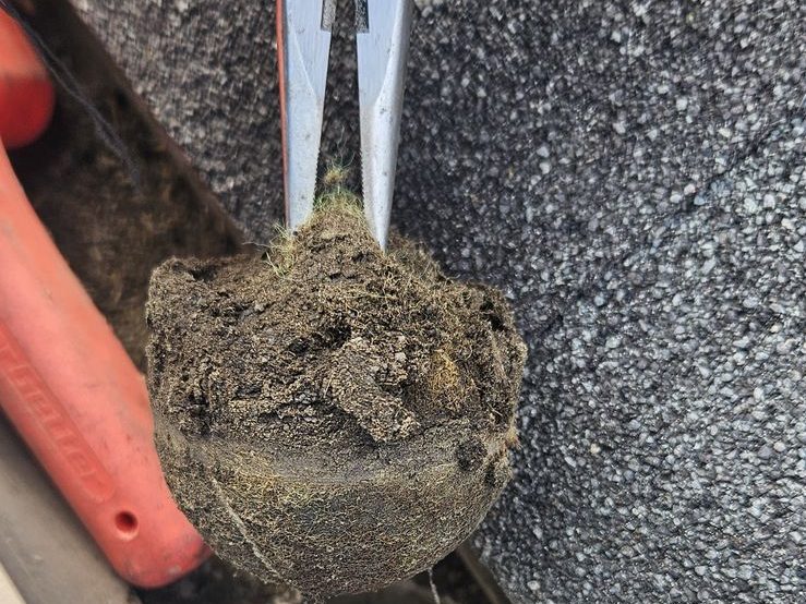 Pulling a packed clog out of a downspout outlet
