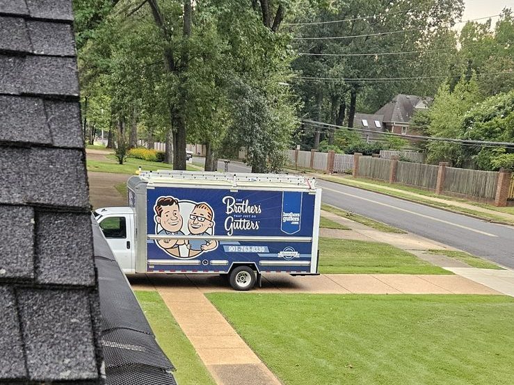 Mesh gutter guard on a finished run with the box truck parked out front