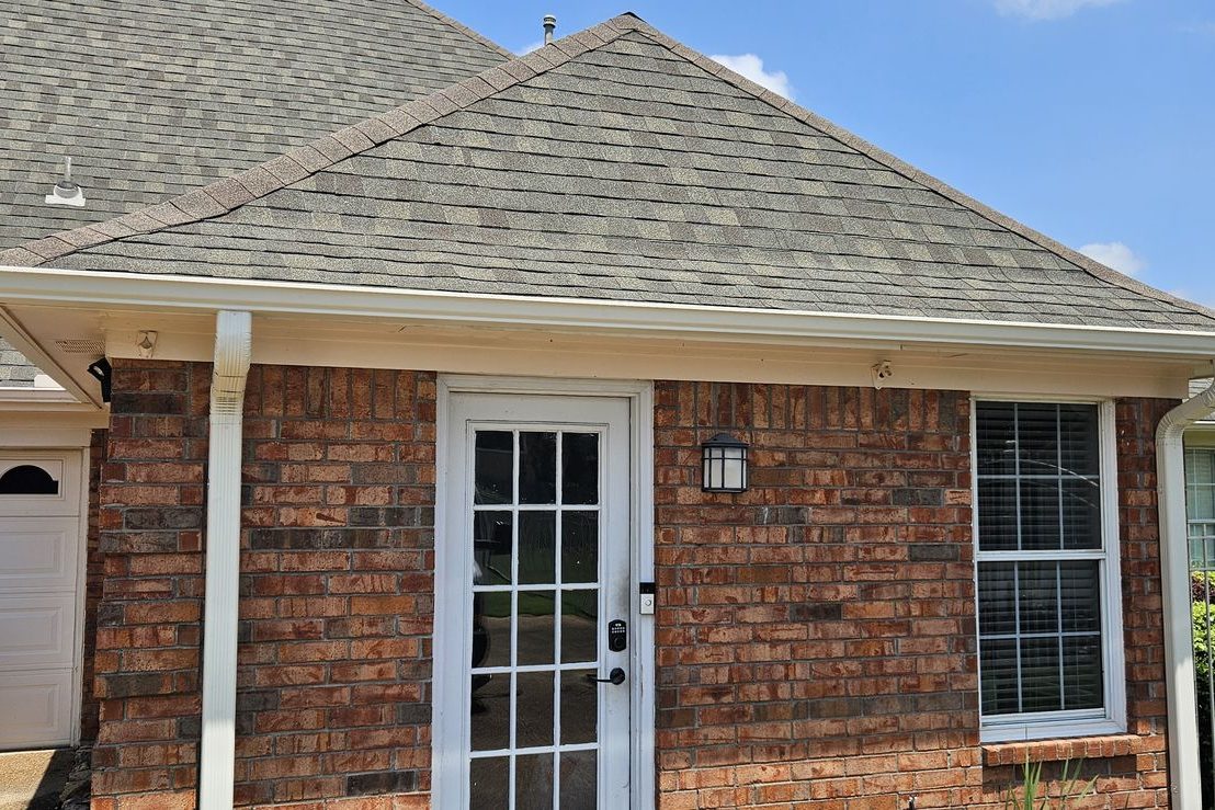 White gutters and downspouts on a single-story brick home